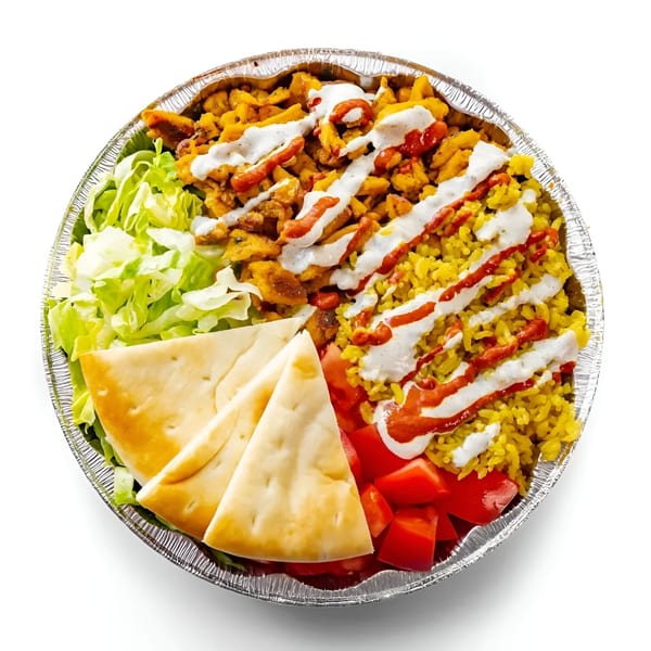 A halal platter with chicken, yellow rice, lettuce, tomatoes, pita bread, white sauce, and hot sauce.